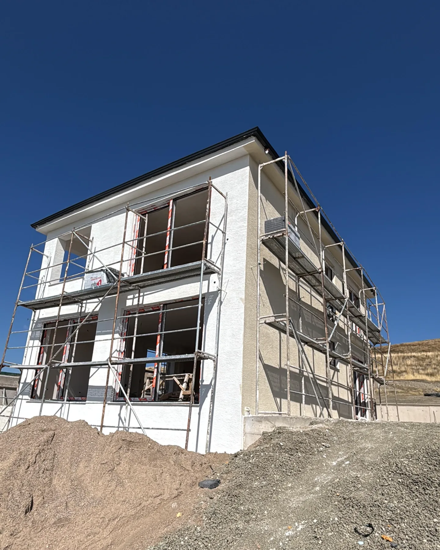 İskele kurulu, açık renk cephe boyası uygulanan villa