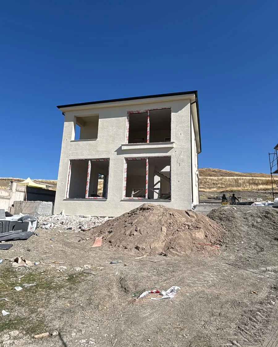 Geniş doğramalı, açık renk cepheli villanın ön görünüşü