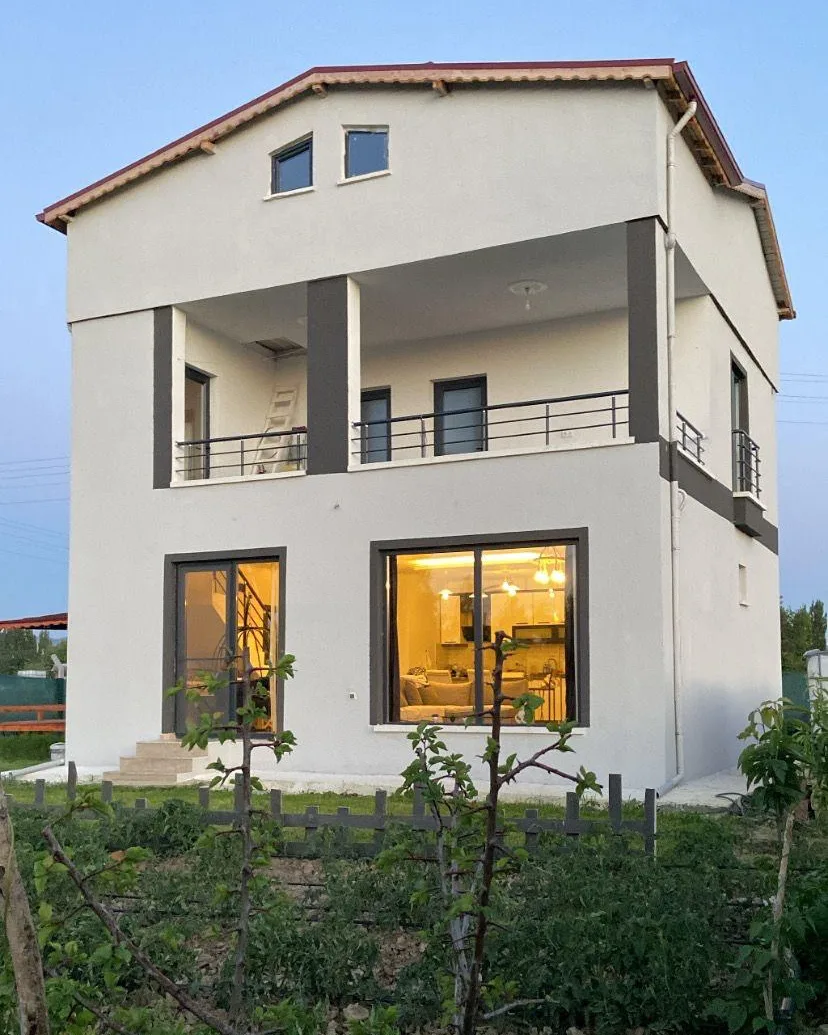 Akşam ışıkları yanan, kapalı teraslı ve çatı katlı müstakil ev